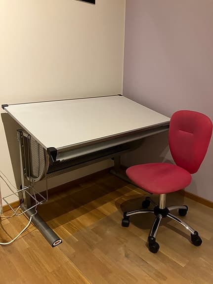 Ställbart skrivbord och skrivbordsstol.