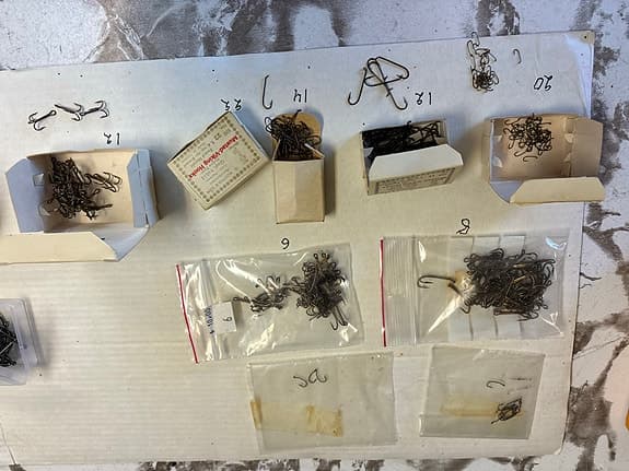 Blandade fiskekrokar i askar och plastlådor