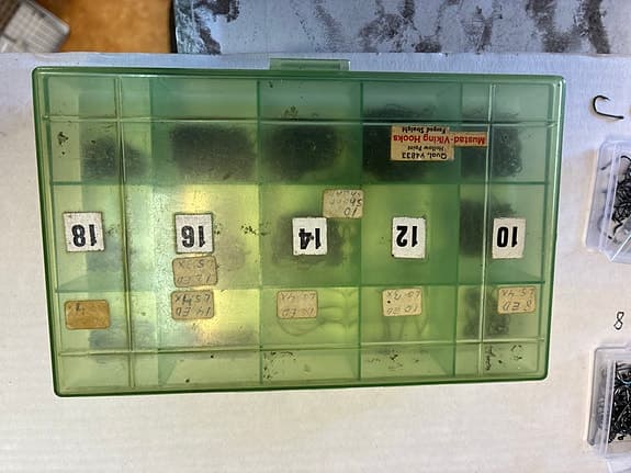 Blandade fiskekrokar i askar och plastlådor