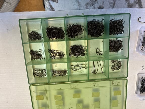 Blandade fiskekrokar i askar och plastlådor