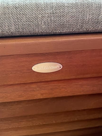 bänk med dyna i tyg och läderdetaljer