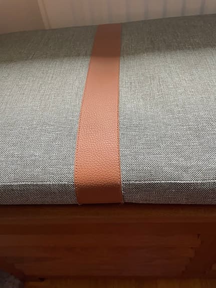 bänk med dyna i tyg och läderdetaljer