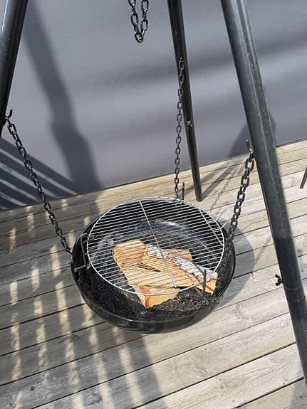 Eldfat och grill på tre ben med hängande grillgaller svart