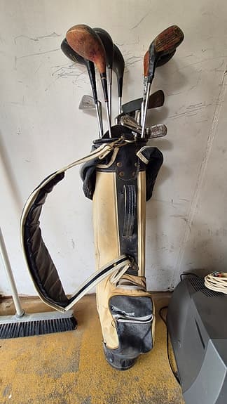 Väldigt gamla golfklubbor och bag.