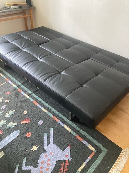 Designad bäddsoffa i svart konstläder 200x115 cm
