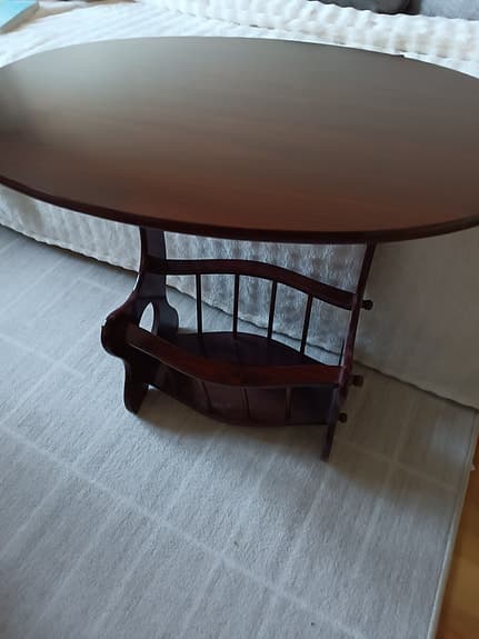 Ovalt tidningsbord i mörkt trä med tidningshylla