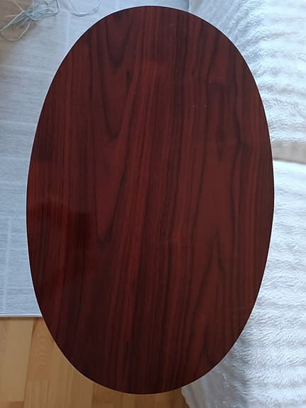 Ovalt tidningsbord i mörkt trä med tidningshylla