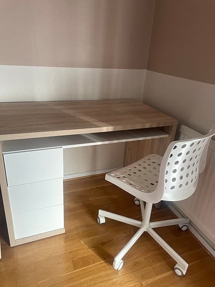 Skrivbord med lådor och vit kontorsstol