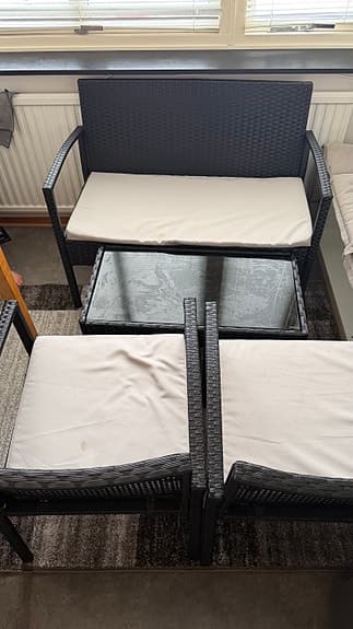 Svart konstrotting loungeset med soffa, två stolar och glasbord