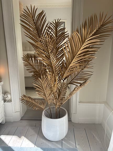 Dekorativ guldfärgad konstväxt palm