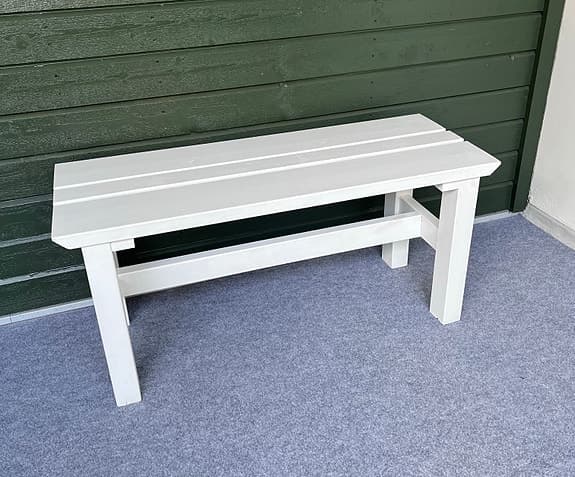 Vit träbänk utomhus