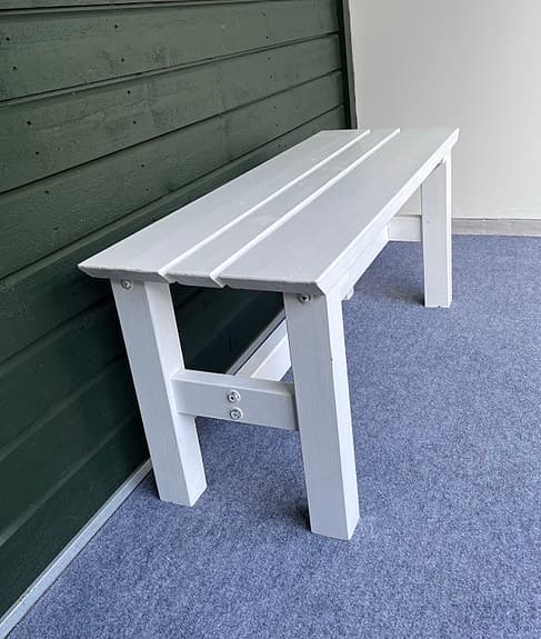 Vit träbänk utomhus