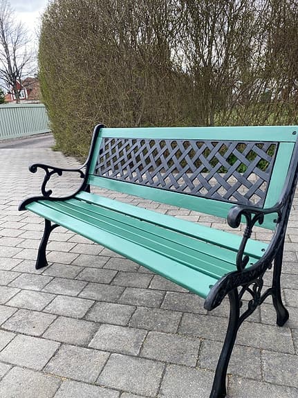 Grön trädgårdsbänk med svart metallstomme