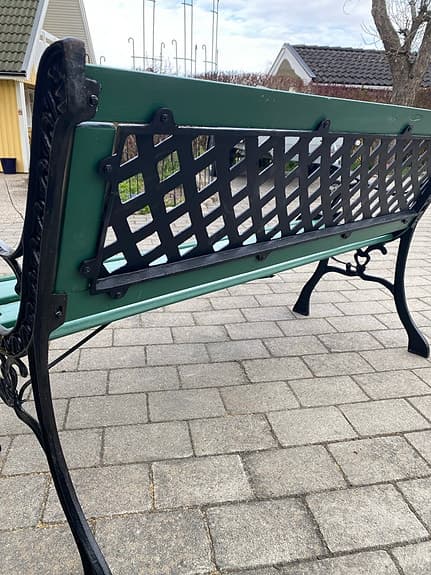 Grön trädgårdsbänk med svart metallstomme
