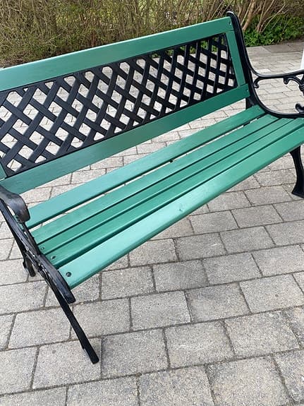 Grön trädgårdsbänk med svart metallstomme