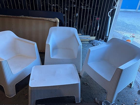 Vita plastfåtöljer med bord för uteplats