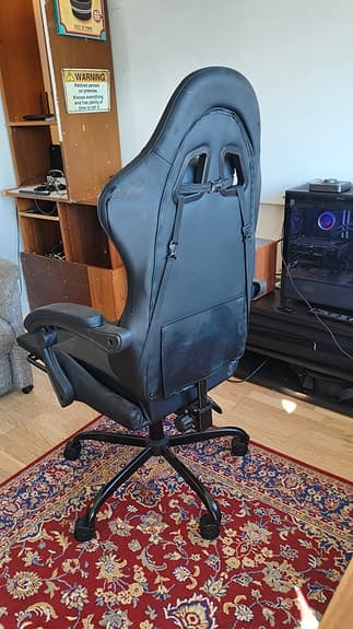 Svart gamingstol med fotstöd och armstöd