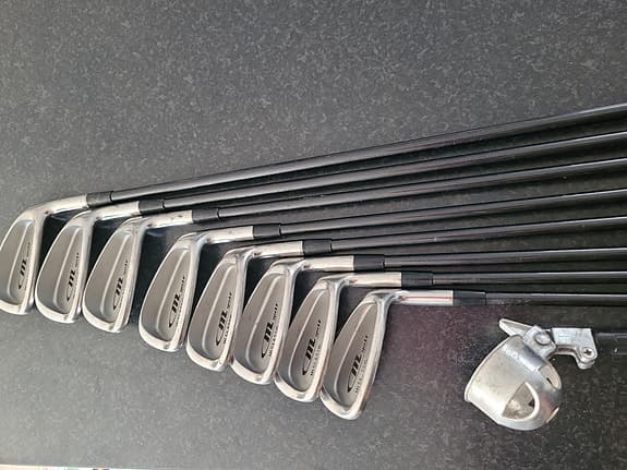 Golfbag med klubbor, bollhåv o nytt paraply.
