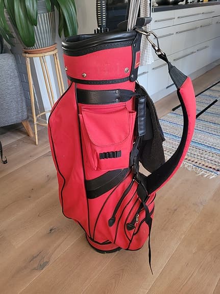 Golfbag med klubbor, bollhåv o nytt paraply.