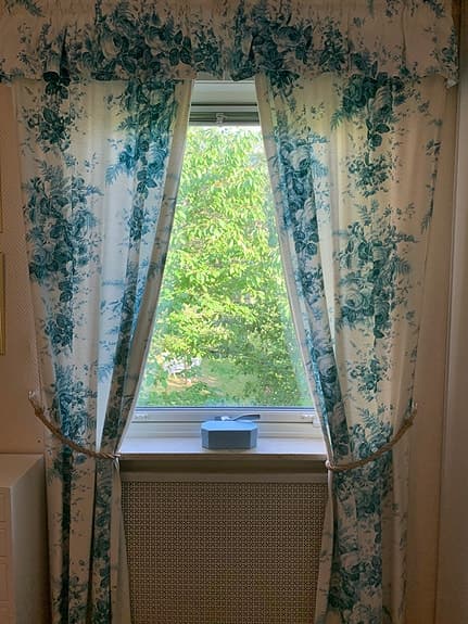 Gardinermed kappa i blå blommigt råsiden