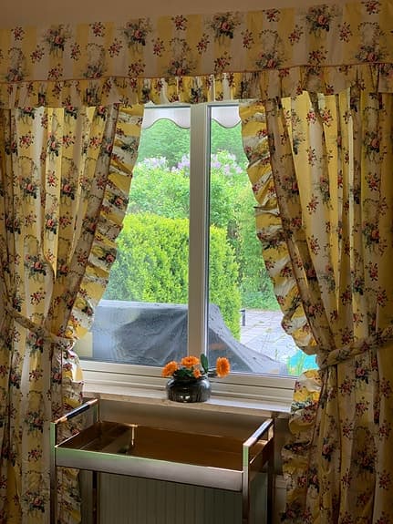 Fodrade Gardiner i blommig chintz med kappa och oktag för ett fönstyer