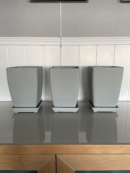 Grå fyrkantiga blomkrukor med fat och dalahästmotiv