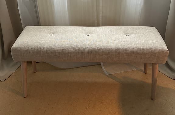 Elegant stoppad bänk i beige och ljust trä