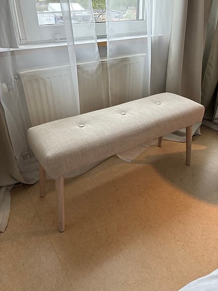 Elegant stoppad bänk i beige och ljust trä