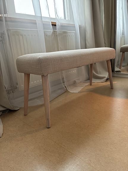 Elegant stoppad bänk i beige och ljust trä