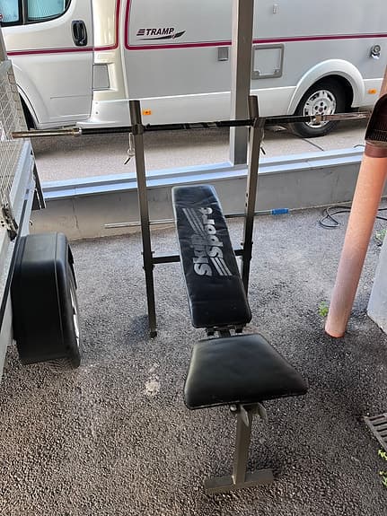 Träningsbänk med skivstång och vikter