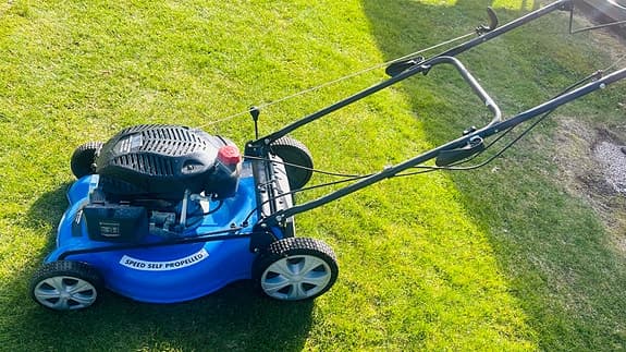 Blå bensindriven gräsklippare med hjuldrift
