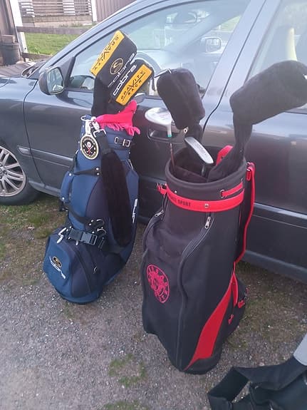 Golfbagar med golfklubbor, bollar mm