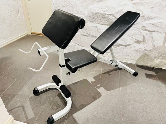 Träningsbänk med justerbart ryggstöd och bicepscurl