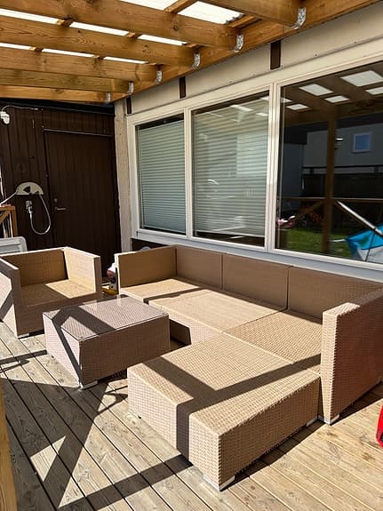 Beige rotting loungesoffa med fåtölj och bord för uteplats
