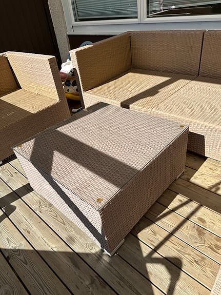 Beige rotting loungesoffa med fåtölj och bord för uteplats
