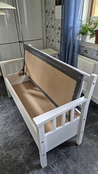 Vit träsoffa med förvaring och grå dyna.