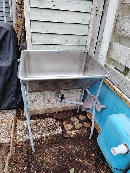 Rostfri diskbänk på ben och lång rostfri bänkskiva med ho