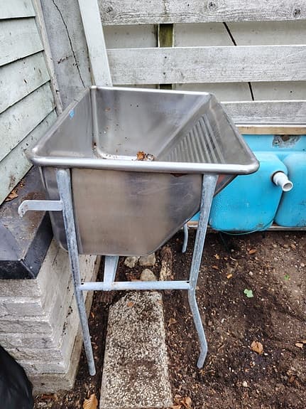 Rostfri diskbänk på ben och lång rostfri bänkskiva med ho