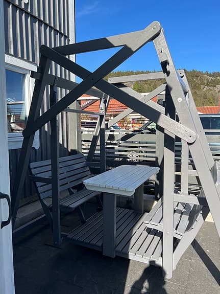 Grå gungsoffa med bord för uteplats