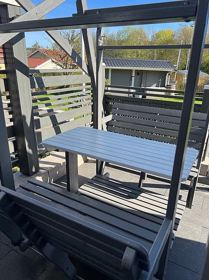 Grå gungsoffa med bord för uteplats