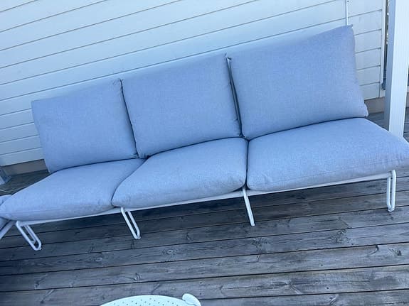 Ute loungesoffa med bord i vitt och grå dynor