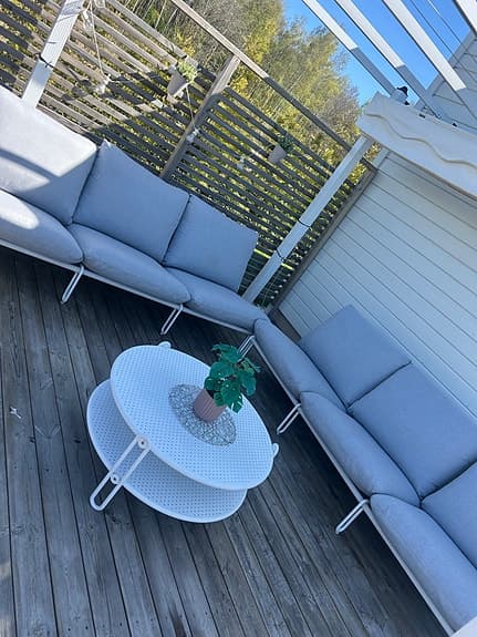 Ute loungesoffa med bord i vitt och grå dynor