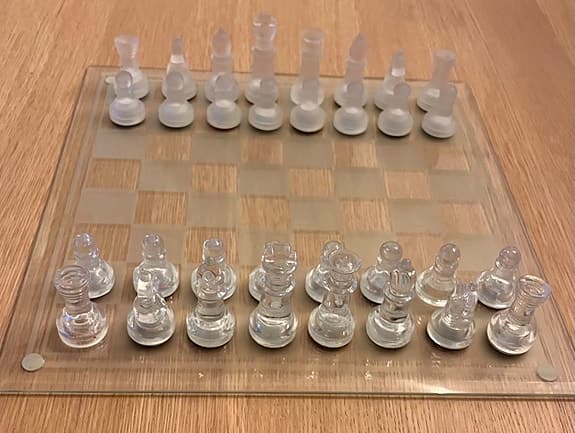 Schackspel i glas med schackbräde