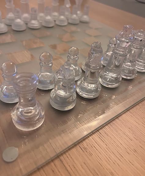 Schackspel i glas med schackbräde