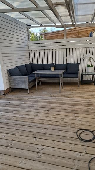 Hörnsoffa i konstrotting med bord för uteplats