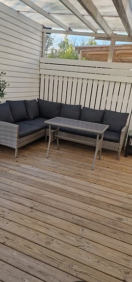 Hörnsoffa i konstrotting med bord för uteplats