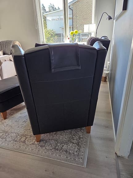 Svarta fåtöljer i skinn med fotpallar