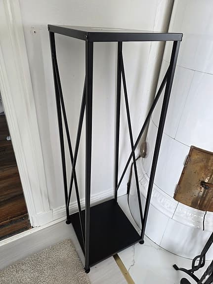 Svart eldställ och vedställ i metall