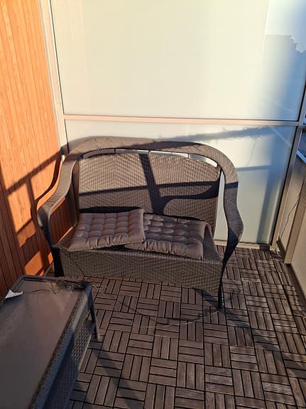 Balkongsoffa i konstrotting med dynor