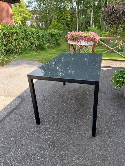 Två trädgårdsbord med glasskiva